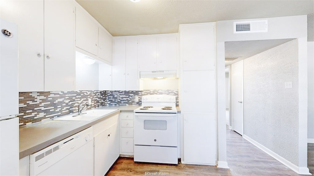 3800 East 29th Street, Unit 18 Bryan, TX 77802 - Photo 13 of 22 a kitchen with white cabinets and white appliances