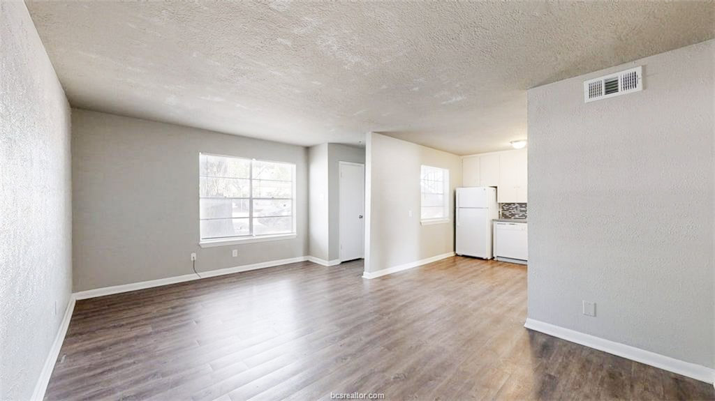 3800 East 29th Street, Unit 18 Bryan, TX 77802 - Photo 14 of 22 an empty room with wooden floor and windows