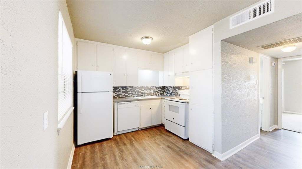 3800 East 29th Street, Unit 18 Bryan, TX 77802 - Photo 19 of 22 a kitchen with white cabinets and white appliances