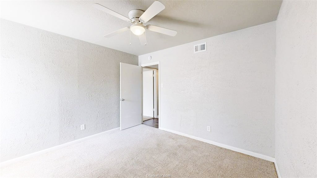 3800 East 29th Street, Unit 18 Bryan, TX 77802 - Photo 6 of 22 an empty room with a ceiling fan and a window