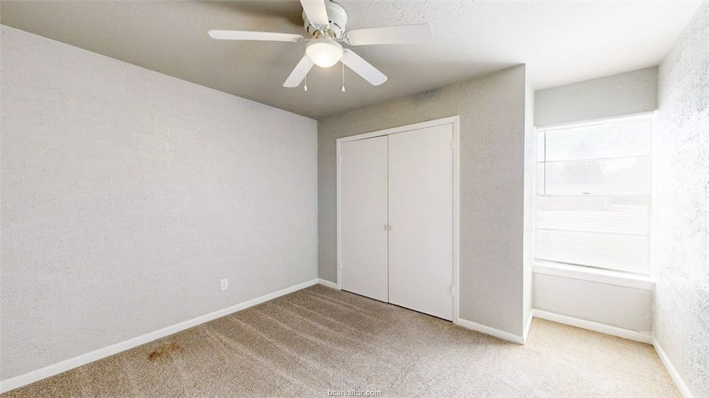 3800 East 29th Street, Unit 18 Bryan, TX 77802 - Photo 7 of 22 an empty room with a ceiling fan and a window
