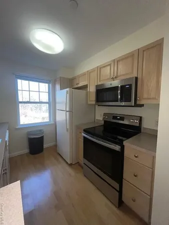 a kitchen with granite countertop a refrigerator stove and microwave