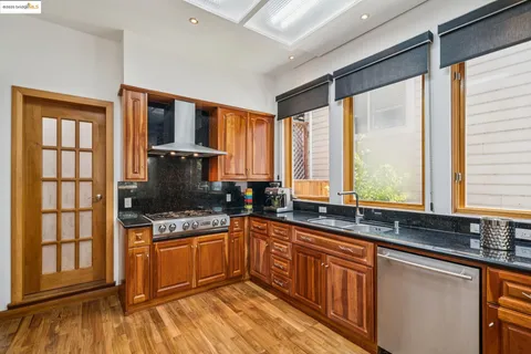 a kitchen with stainless steel appliances granite countertop a stove a sink and a microwave