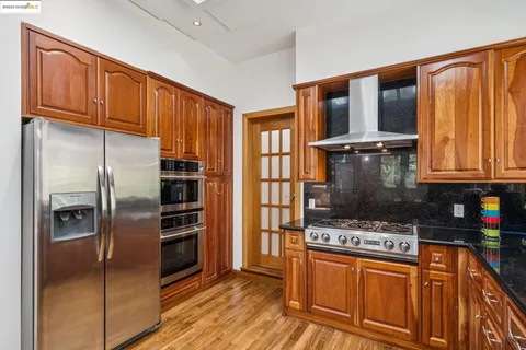 a kitchen with stainless steel appliances granite countertop a refrigerator stove and oven