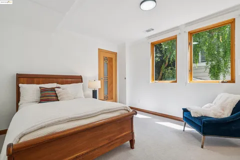 a bedroom with a bed and a painting on the wall