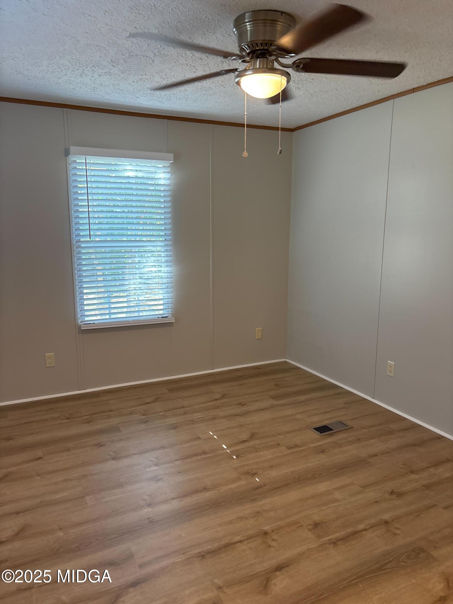 137 Alview Drive Macon, GA 31206 - Photo 16 of 22 an empty room with wooden floor chandelier fan and windows