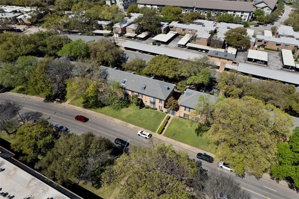 an aerial view of a house with a yard and mountain view in back