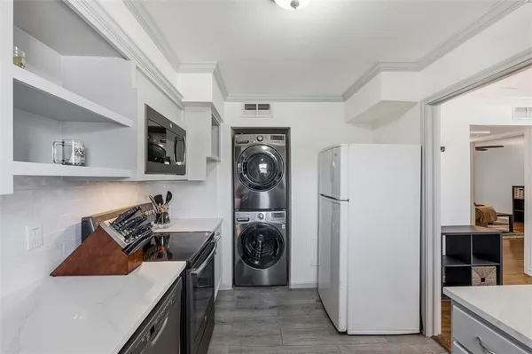 a kitchen with stainless steel appliances granite countertop a refrigerator a stove and a sink
