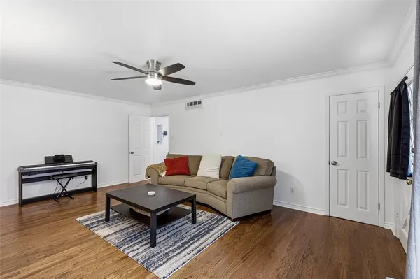 a living room with furniture and a wooden floor