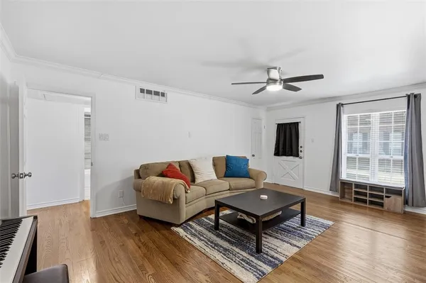 a living room with furniture and a wooden floor