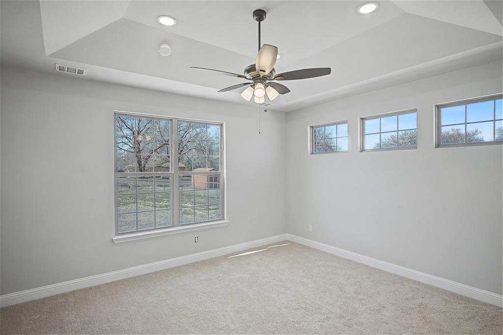 44 Karol Jean Way Quinlan, TX 75474 - Photo 16 of 36 Carpeted empty room featuring ceiling fan, a raised ceiling, and recessed lighting