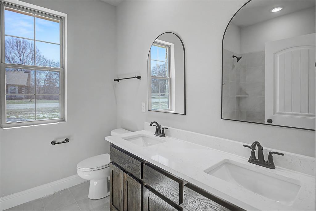 44 Karol Jean Way Quinlan, TX 75474 - Photo 22 of 36 Full bath featuring double vanity, light tile patterned floors, and tiled shower
