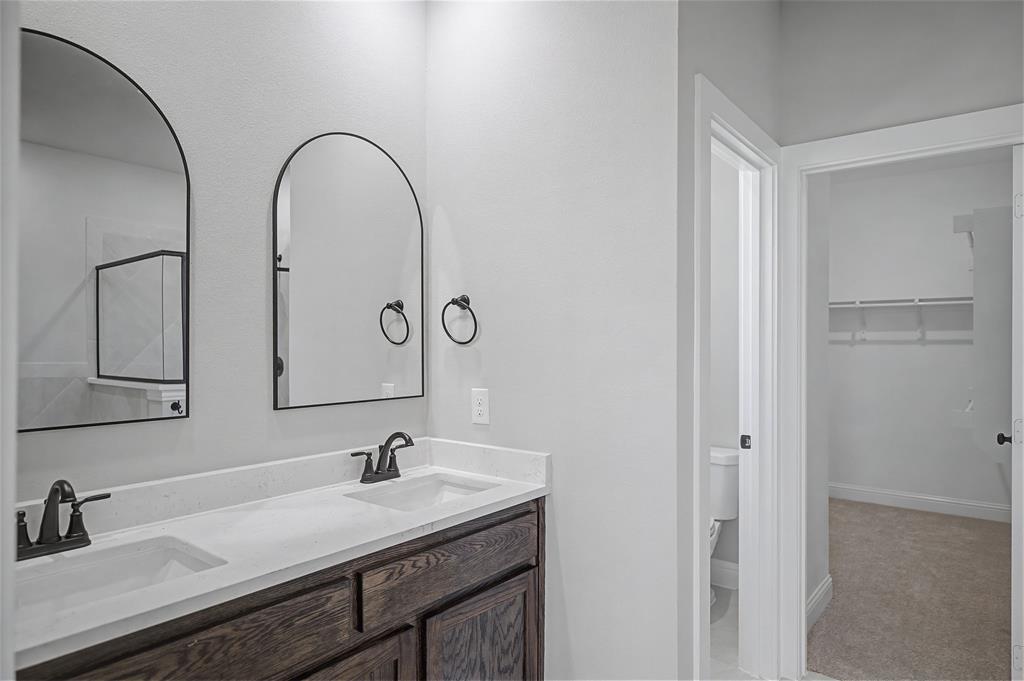 44 Karol Jean Way Quinlan, TX 75474 - Photo 24 of 36 Bathroom with double vanity, a walk in closet, and light carpet