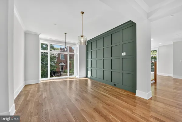 a view of an empty room with wooden floor fireplace and a window
