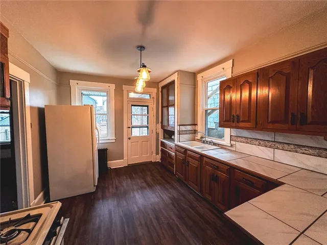 a large kitchen with a wooden floor and cabinets