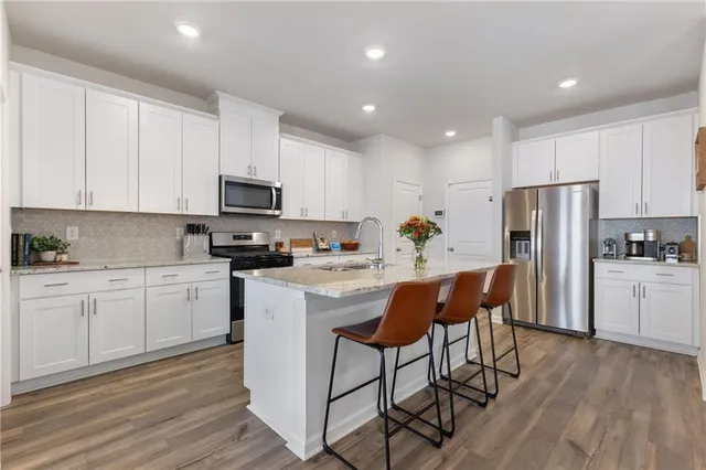 a kitchen with stainless steel appliances granite countertop a refrigerator sink and cabinets