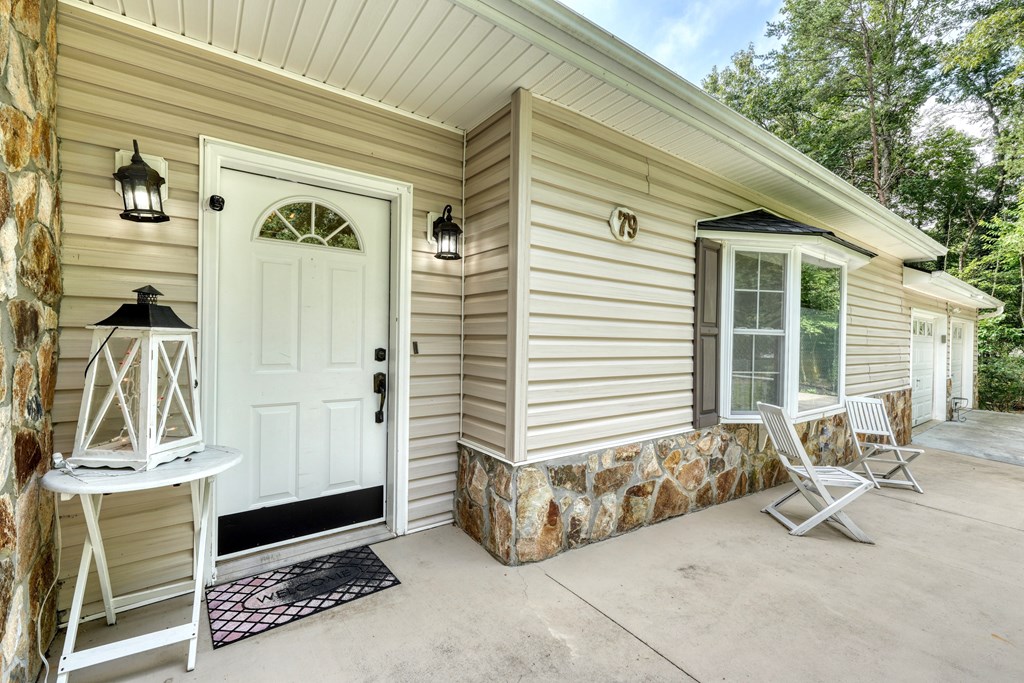 79 Mashie Lane Murphy, NC 28906 - Photo 18 of 76 a view of a porch with a table and chairs and potted plants