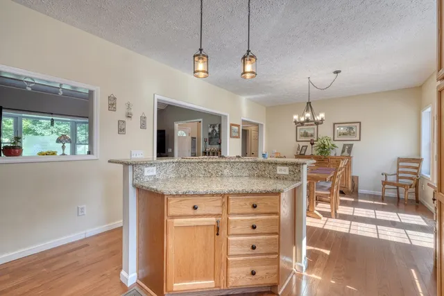 a bathroom with a granite countertop sink a toilet and a mirror