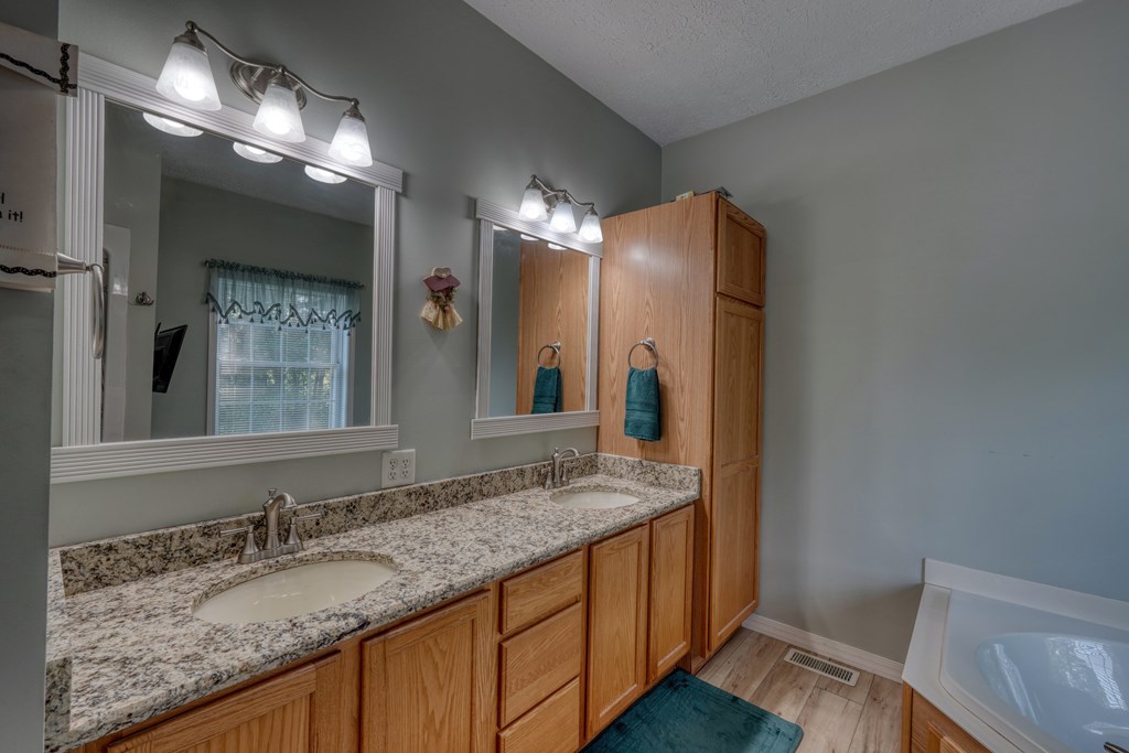 79 Mashie Lane Murphy, NC 28906 - Photo 33 of 76 a bathroom with a granite countertop sink and a mirror