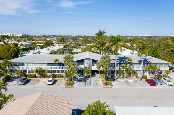 an aerial view of residential houses with outdoor space and trees