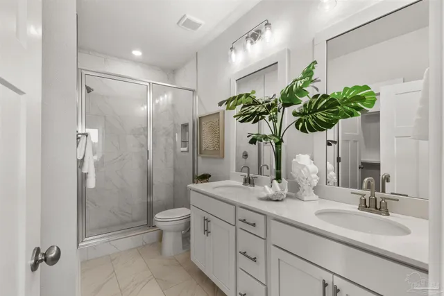 a bathroom with a granite countertop sink a toilet and shower