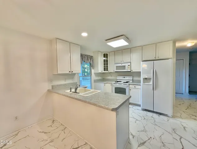 a kitchen with granite countertop a sink stove and refrigerator