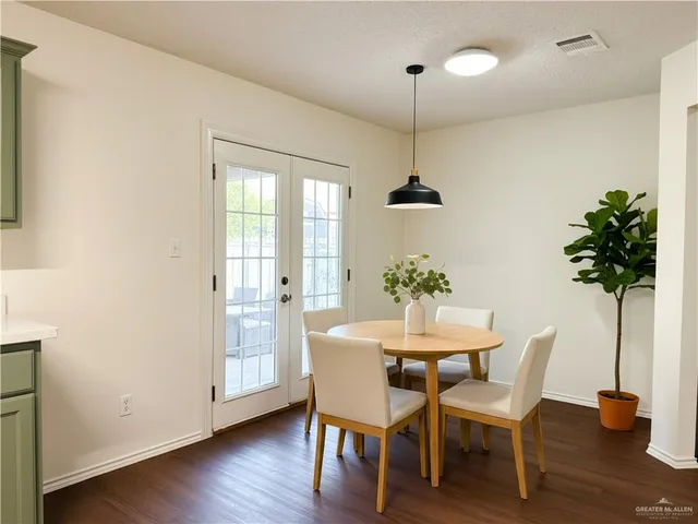 a dining room with furniture potted plants and wooden floor
