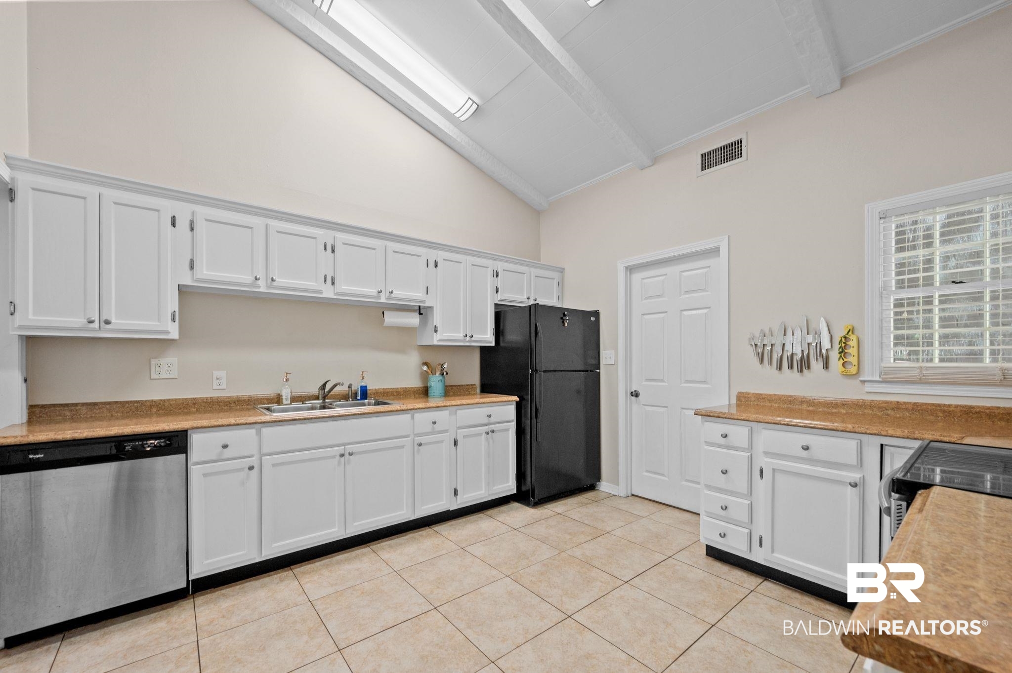 110 Ferncliff Circle Daphne, AL 36526 - Photo 13 of 40 Kitchen with stainless steel appliances, a sink, high vaulted ceiling, beam ceiling, and light tile patterned floors