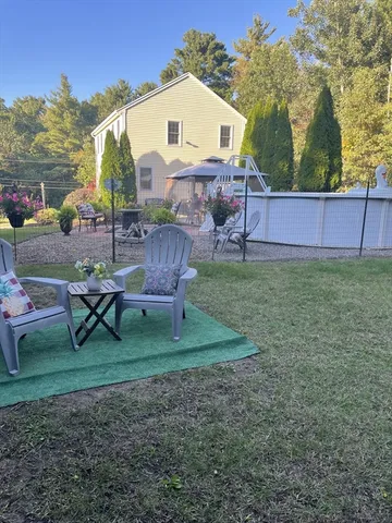 a view of a house with backyard and sitting area
