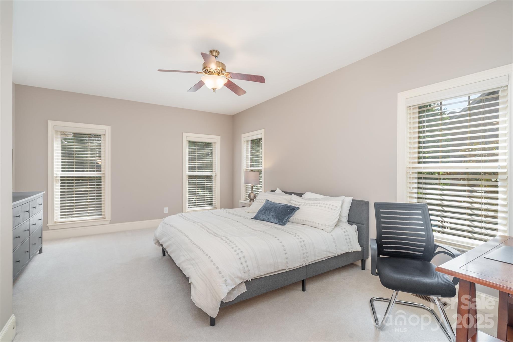 9021 Unbridle Lane Waxhaw, NC 28173 - Photo 27 of 48 a bedroom with a large bed chandelier and a window