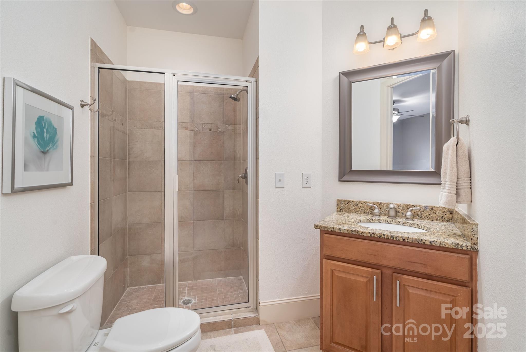 9021 Unbridle Lane Waxhaw, NC 28173 - Photo 33 of 48 a bathroom with a granite countertop sink toilet and shower