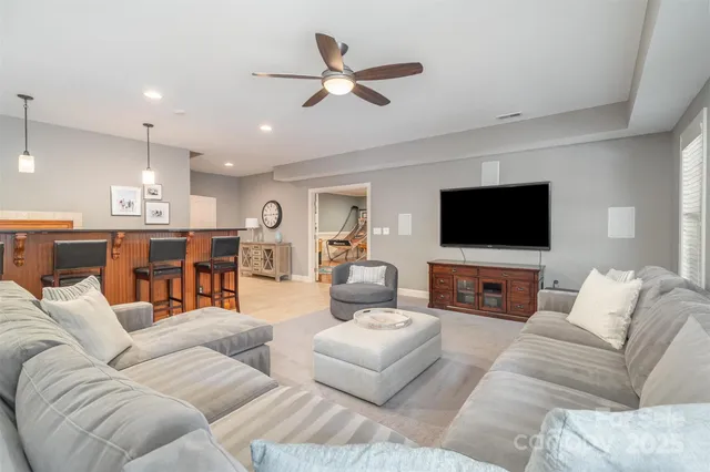 a living room with furniture kitchen view and a flat screen tv