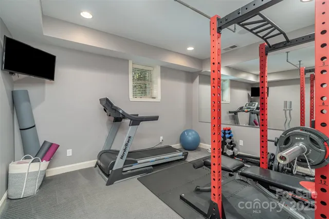 a room with gym equipment and a flat screen tv