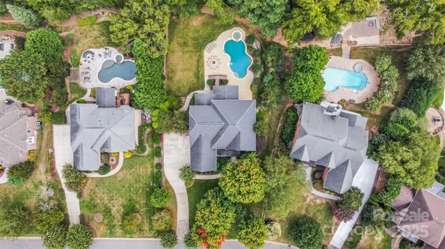 an aerial view of a house with a yard and a large tree