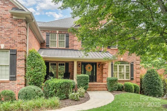 front view of a brick house with a yard