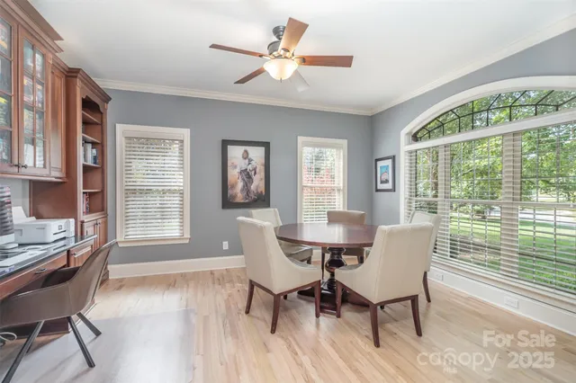 a dining room with furniture a chandelier and wooden floor