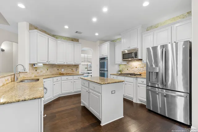 a kitchen with granite countertop stainless steel appliances a refrigerator sink and microwave