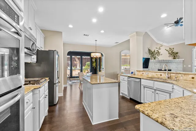 a kitchen with stainless steel appliances granite countertop sink stove top oven and refrigerator