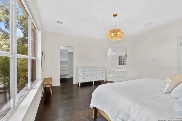 a bedroom with a bed and a chandelier