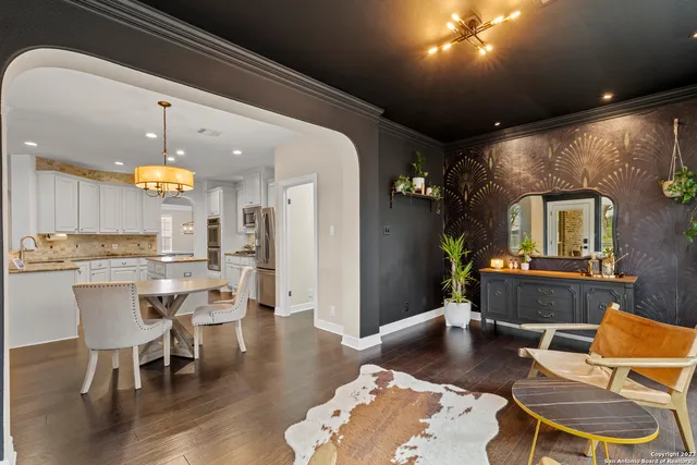 a dining room with wooden floor and a chandelier