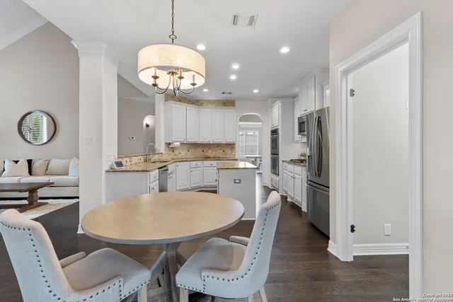 a kitchen with stainless steel appliances kitchen island granite countertop a kitchen island a stove a table and chairs