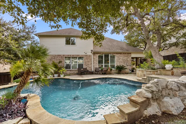 a view of a house with swimming pool and sitting area
