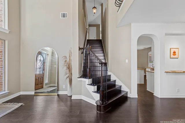 a view of a hallway with entryway wooden floor and stairs