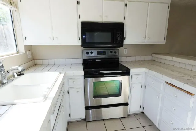 a kitchen with granite countertop a stove and a sink