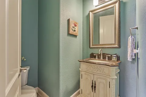 a bathroom with a toilet sink vanity and mirror
