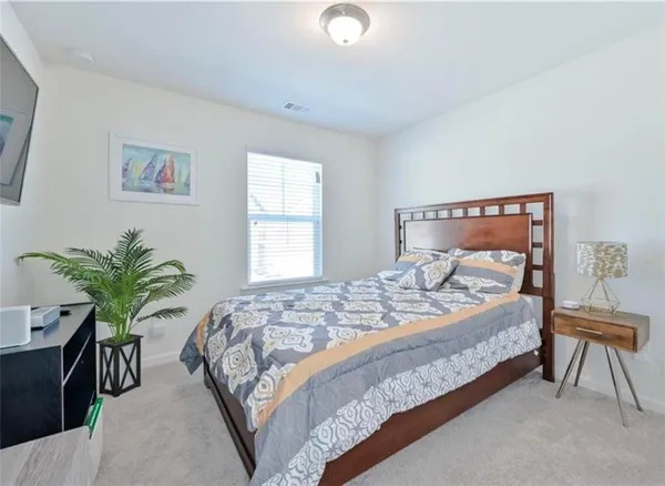 a bedroom with bed and a potted plant
