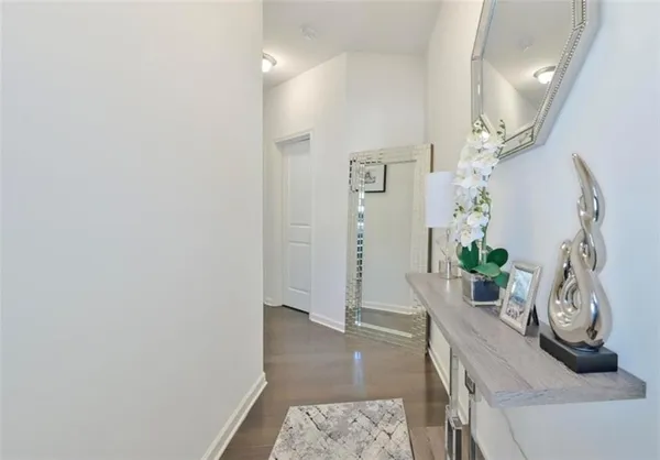 a view of a hallway with wooden floor and a potted plant