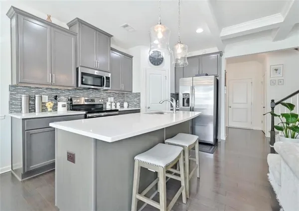 a kitchen with kitchen island granite countertop a sink cabinets and stainless steel appliances