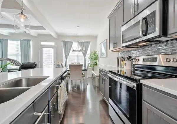 a kitchen with stainless steel appliances granite countertop a lot of cabinets