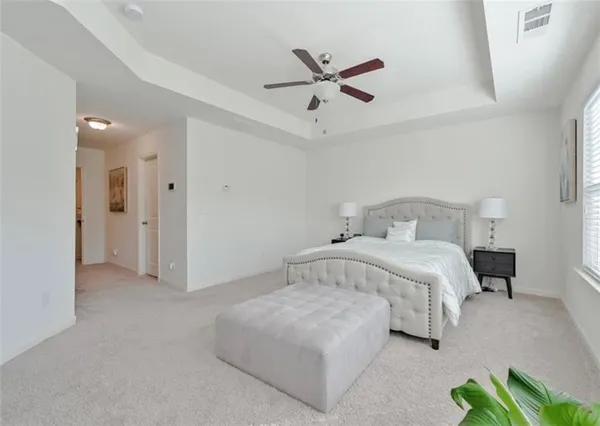 a bedroom with a bed and painting on the wall